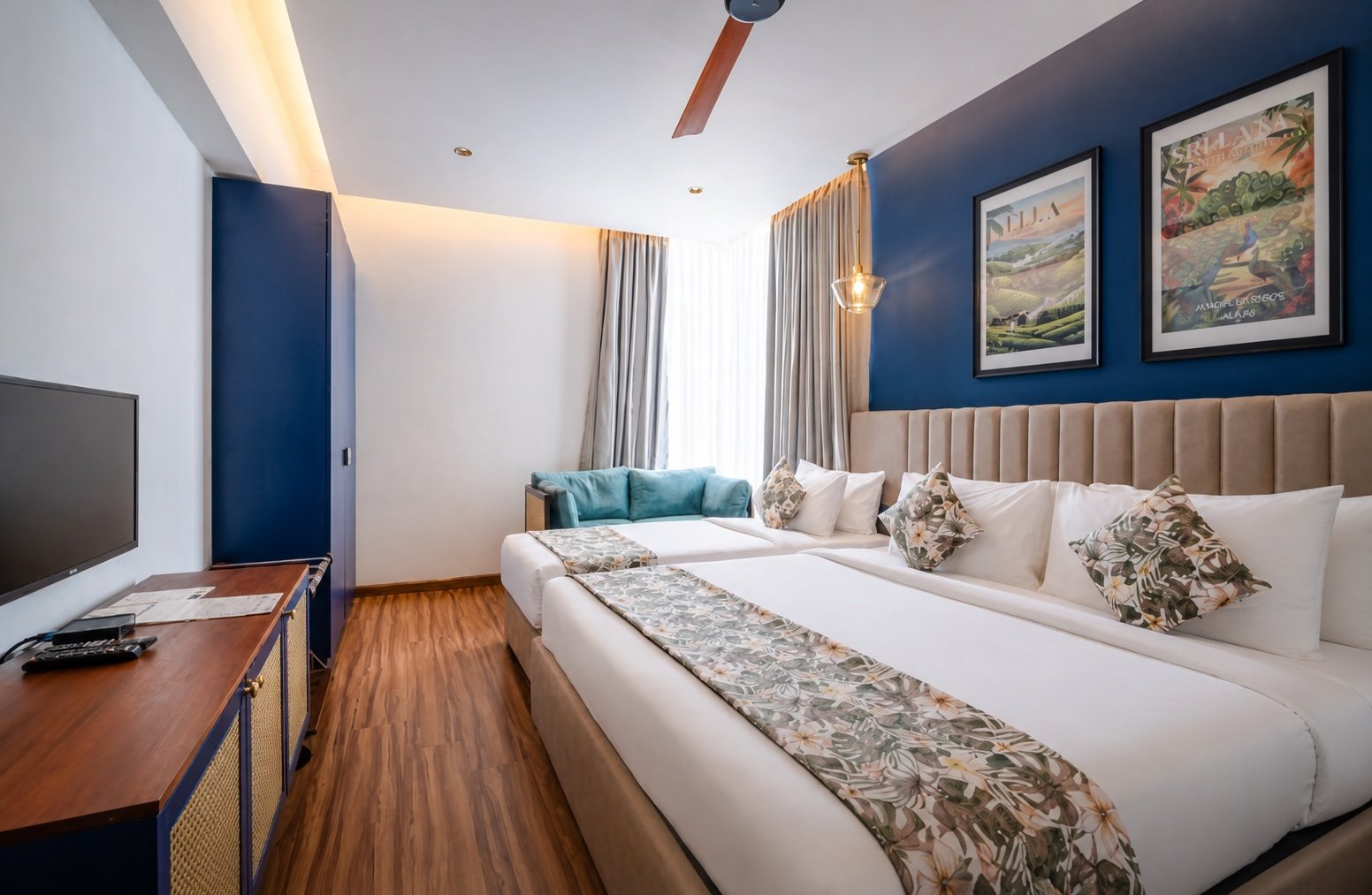 Superior Triple Room with king and single beds against a blue feature wall at MK Colombo